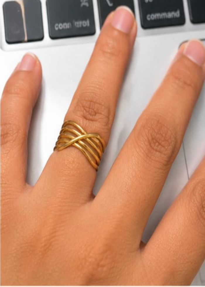 Hand wearing a gold ring on a keyboard